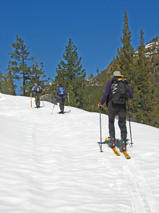 Image of skiers ascending along road