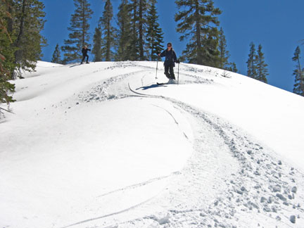 Image of skiers descending the open area high above the railroad tracks