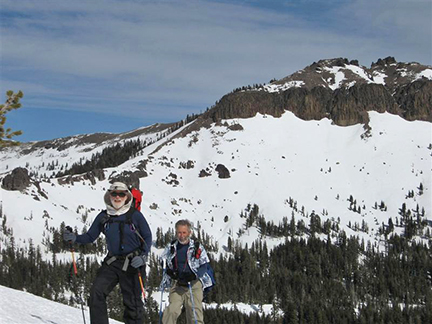 Image of skiers on steep section along ridge with Castle Peak in backgound.