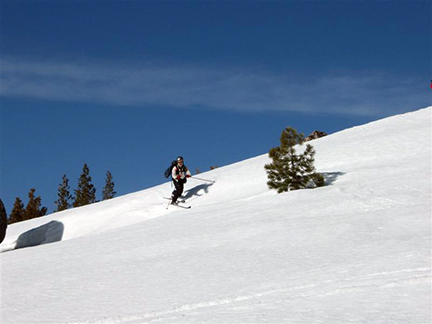 Image of skier crossing open area on descent from Andesite Peak.