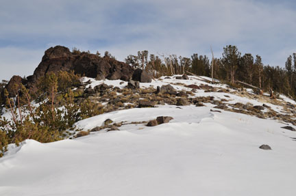 Image of red rock outcropping and spares snow on ridge