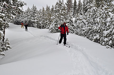 Image of skiers on road to Chipmunk Bluff after new snowfall