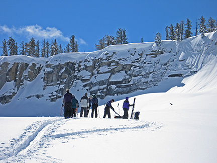 Image of skiers attaching climbing skins before final climb to top of Horse Ridge